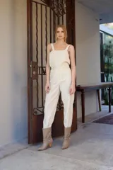 Bota corta de cuero color visón, con taco de madera y punta fina. Presenta apliques de gamuza en los laterales y tachas metálicas. Incluye una cadena metálica desmontable alrededor del tobillo.