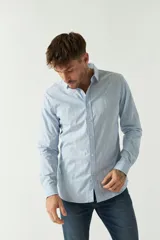 Camisa de hombre de corte slim fit, confeccionada en algodón con diseño de rayas verticales finas en tonos claros. Presenta cuello clásico, cierre frontal con botones y logo bordado en el pecho.