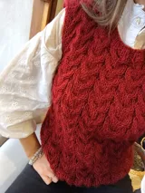 Chaleco tejido a mano color ladrillo con diseño texturizado.