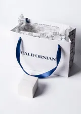 Anillo de plata 925 con piedra central de zirconia en corte oval color violeta, flanqueada por pequeñas piedras de zirconia transparentes a cada lado.