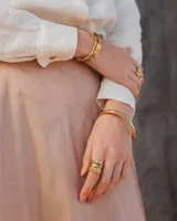 Anillo de diseño enlazado con textura irregular, realizado a mano en bronce. Presenta un diseño abierto que permite regular su tamaño con suavidad.