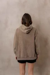 Canguro oversize fucsia con efecto washed, capucha con cordones ajustables al tono, bolsillo frontal tipo canguro y terminaciones de rib en puños y cintura.