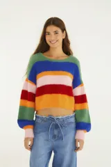 Sweater cropped de tejido de punto con acabado afelpado y diseño de rayas multicolor. Presenta cuello redondo, mangas largas y silueta amplia, combinando textura suave con un estilo vibrante y moderno.