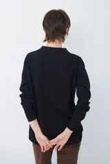 Cardigan de punto color beige, con cuello camisero, cierre frontal de botones y bolsillo aplicado en el pecho. Presenta mangas largas con puños acanalados y un corte recto y holgado.
