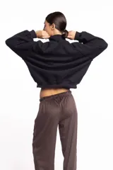 Campera negra de cuello alto con cierre frontal metálico completo, bolsillos laterales y logo bordado en el pecho.