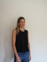 Blusa sin mangas de algodón color blanco, con delicadas tablas en el frente y terminaciones levemente desflecadas, de corte suelto y liviano.