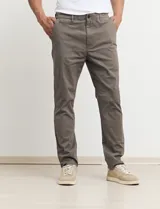 Pantalón de gabardina de corte recto y tiro medio, con bolsillos laterales y traseros, y cierre frontal con botón y cremallera.