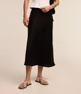 Pollera midi evasé de color beige claro, confeccionada en tela satinada de poliéster.