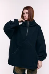 Canguro oversize confeccionado en denim negro 100% algodón, con capucha, cuello alto con cierre metálico frontal, bolsillo frontal tipo canguro y puños con elástico.