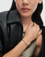 Pulsera PD Paola con cordón negro y dije dorado en forma de flecha.