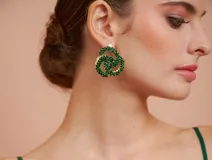 Aros colgantes con forma de nudo, recubiertos de strass color verde esmeralda.