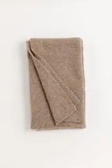 Ruana de tejido de punto en color beige, con diseño rectangular y textura suave.