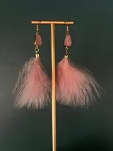 Aros colgantes de plumas negras con detalle de piedra natural oscura y herrajes dorados.