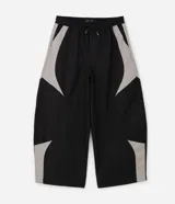 Pantalón barrel de poliéster color negro con recortes contrastantes en tono gris claro en los laterales, de corte amplio y urbano con cintura elástica.