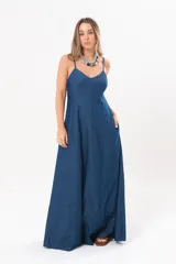 Vestido largo de denim fino y liviano, color azul, con breteles finos, escote en V y falda amplia con recortes verticales y bolsillos laterales.