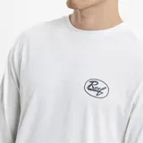 Remera de manga larga color gris, con cuello redondo y pequeño logo de la marca Reef estampado en color amarillo sobre el pecho.