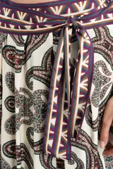 Falda larga fluida de diseño envolvente con estampado paisley en tonos bordó, negro y blanco, con cintura alta decorada con cenefa geométrica y lazo lateral.