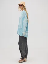 Sweater de tejido de punto con diseño holgado y largo, de manga larga con puños acanalados y aberturas laterales. Presenta un acabado con efecto desteñido.