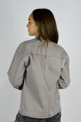 Camisa marrón con cuello camisero, cierre frontal con botones, mangas largas y bolsillos plaqué con solapa en el pecho.