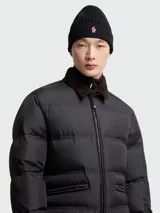 Gorro de lana con diseño de punto elástico en color negro, con vuelta y el icónico parche del logotipo de Moncler en la parte frontal.