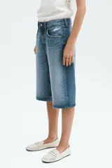 Bermuda de cinco bolsillos en denim de algodón rígido, color celeste con efecto desgastado. Modelo de corte holgado con cierre y botón metálico.