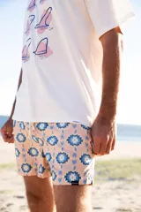 Short de baño rosado con estampado geométrico en azul y blanco, cintura elástica azul y cordón ajustable blanco.