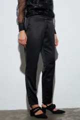 Pantalón sastrero negro de satén, tiro medio y corte recto.