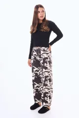 Jean de corte recto y tiro alto con estampado animal print tipo vaca en blanco y negro. Cuenta con cierre frontal, botón metálico y bolsillos laterales y traseros.