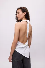 Top de algodón con diseño de rayas verticales multicolor, cuello buche y terminación irregular en punta. Presenta espalda semi descubierta y un calce holgado y fresco.