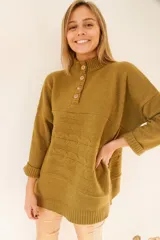 Sweater tejido color ocre con cuello alto y botones de madera.