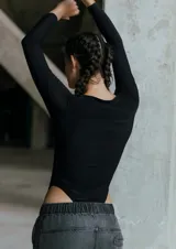 Body de microfibra color negro, con escote redondo a la base, manga larga y cierre con broche snap en el tiro.