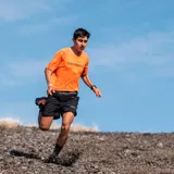 Remera deportiva de manga corta color naranja, con logo de la marca estampado en el frente. Confeccionada en tejido técnico elástico de secado rápido, ideal para actividades al aire libre.