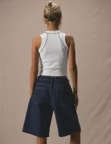 Top ajustado de cuello redondo y sin mangas, con costuras visibles en contraste que resaltan el diseño. Presenta un corte cropped y una silueta minimalista.