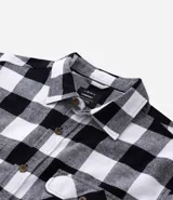 Camisa de franela a cuadros rojos y negros, de corte regular, manga larga y cuello inglés.