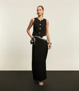 Pollera lápiz midi de tejido plano con corte sastre, color negro. Presenta traspase en la cintura y pences en la parte trasera. Confeccionada en poliéster y elastano.