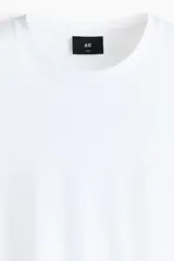 Remera de corte ajustado en punto suave de algodón pima, color blanco, con cuello redondo y mangas cortas.