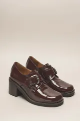 Zapato de cuero vacuno color borgoña con acabado charol, taco cuadrado de 4 cm y hebilla lateral.