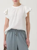 Blusa de algodón orgánico y ramie, color blanco, con cuello redondo y mangas cortas adornadas con detalles de crochet.