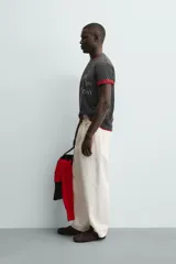 Camiseta de manga corta y cuello redondo, color negro con efecto lavado. Presenta un estampado frontal con un corazón rojo y texto en blanco que dice "Kinda Care Kinda Don't".