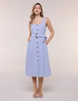 Vestido midi abotonado verde melange, con escote recto, tirantes anchos y falda de calce recto con vuelo sutil. Tiene abotonadura frontal completa con botones estilo carey, cinto textil con hebilla para ajustar la cintura y bolsillos laterales.