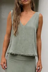 Blusa de lino tusor sin mangas, color verde militar, con escote en V y calce relajado. Presenta detalles de flecos en el ruedo.