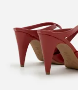 Zapato mule color rojo charol con punta fina y tiras cruzadas sobre el pie. Tacón fino de 8,5 cm de altura.