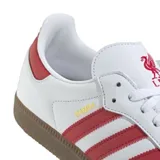 Championes Adidas modelo Samba, de diseño clásico con base de cuero blanco, franjas laterales rojas, puntera de gamuza gris y suela de goma color caramelo.