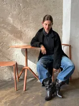 Botas de cuero negro de caña media con diseño fruncido tipo slouchy, punta fina y taco bajo.