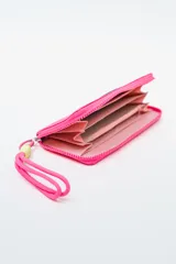 Billetera rectangular con cierre, color celeste pálido, con parche frontal negro que lleva las letras "CNJ" en relieve. Incluye un llavero de muñequera con cordón trenzado en rosa fuerte y verde lima.