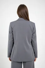 Blazer de corte recto en color gris, con solapas clásicas, bolsillos laterales con solapa y diseño de estructura entallada.
