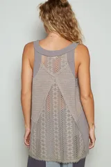 Top sin mangas de color gris, con escote en V acordonado y paneles laterales de encaje tejido. Presenta un diseño holgado con terminaciones deshilachadas en el ruedo.