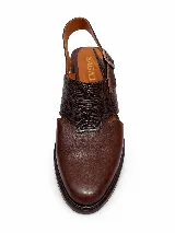Zapato destalonado de cuero marrón con puntera cerrada, detalles de textura grabada en la capellada y tira ajustable con hebilla en el talón, con taco bajo y ancho.