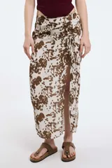 Pollera midi de viscosa con estampado animal print, frunce regulable y tajo frontal. Posee cierre invisible y cintura elastizada.