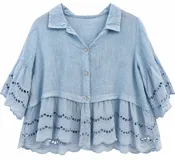 Camisa celeste de lino, con cuello camisero, cierre frontal de botones y mangas 3/4 anchas. Presenta detalles de bordado inglés calado en los puños y en el ruedo con volados.
